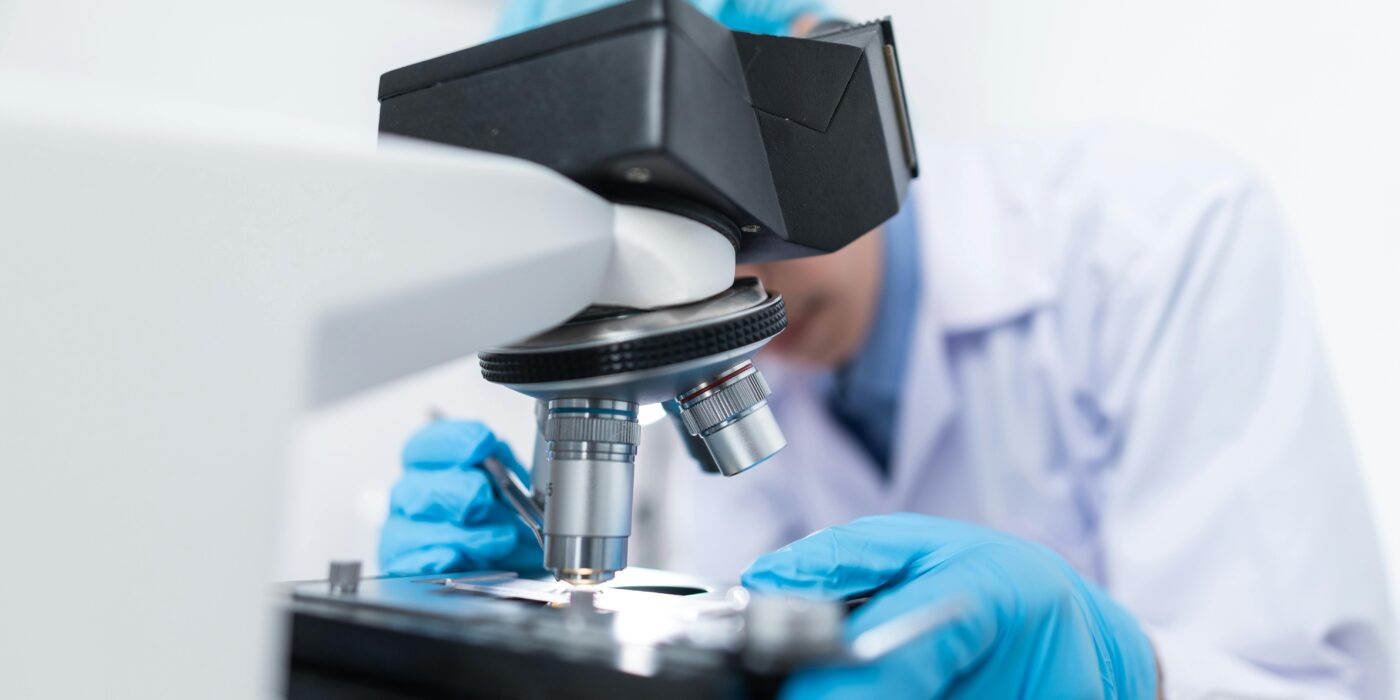 Scientists in a laboratory with microscope conducting life science research and development.