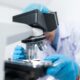 Scientists in a laboratory with microscope conducting life science research and development.