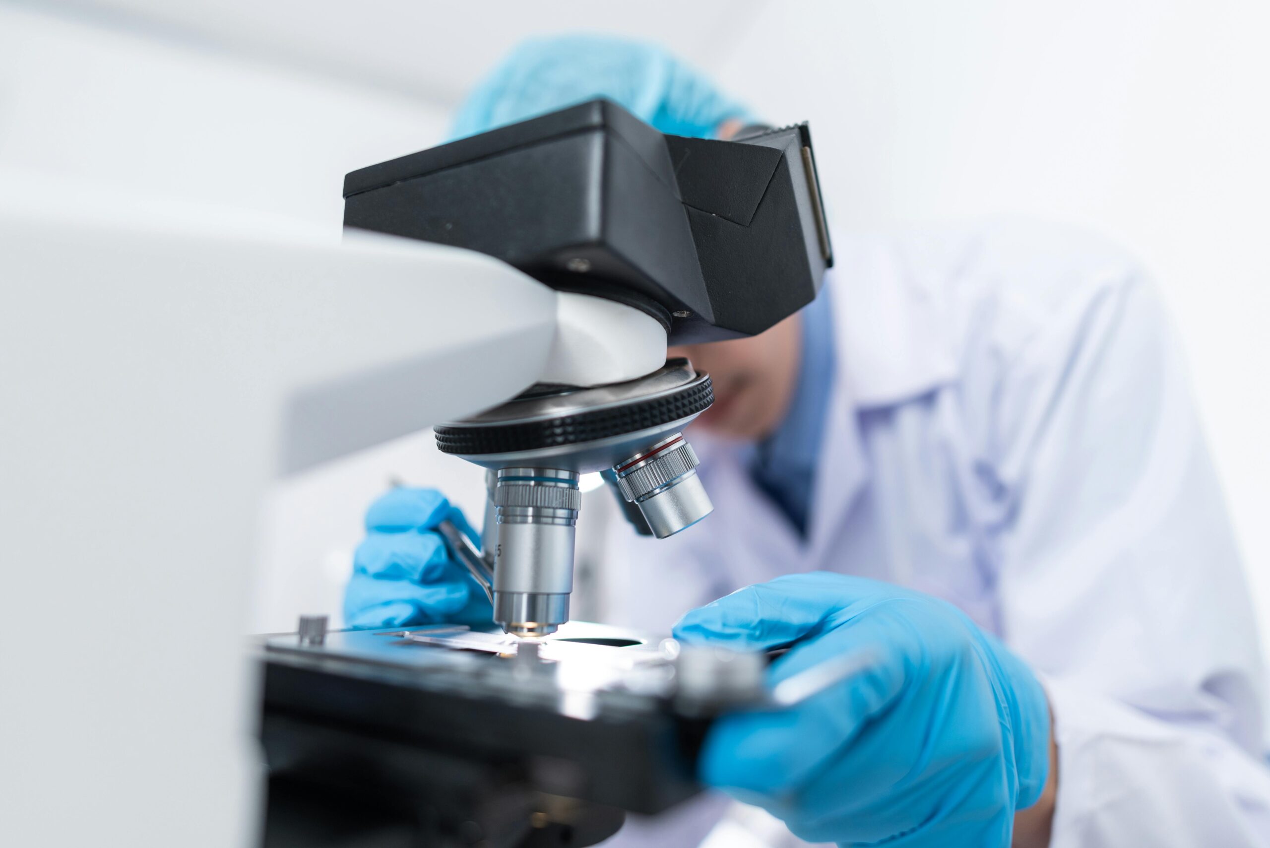 Scientists in a laboratory with microscope conducting life science research and development.